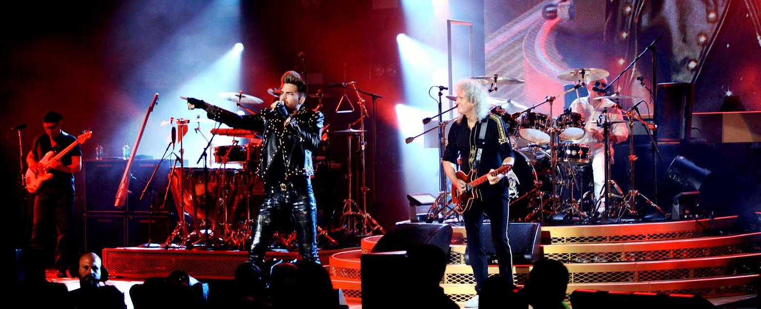Photo of Adam Lambert, Brian May and Roger Taylor performing