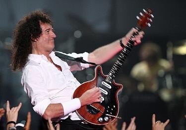 Photo of Brian May playing his guitar on stage