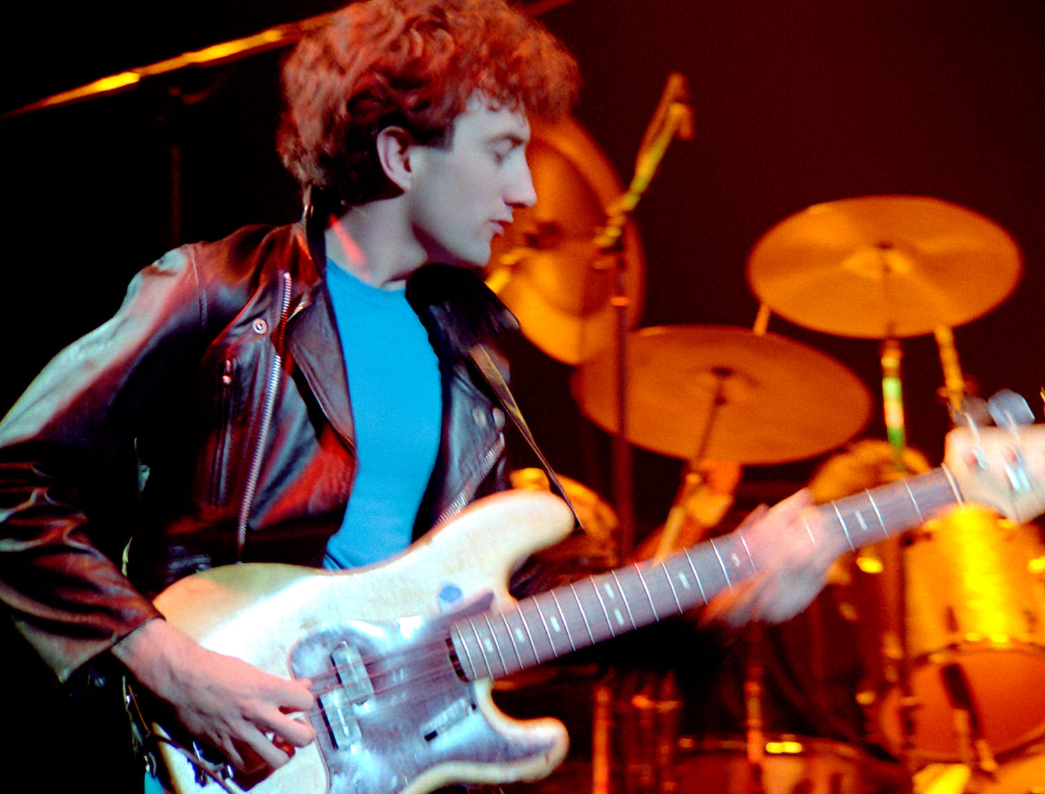 Photo of John Deacon playing bass on stage